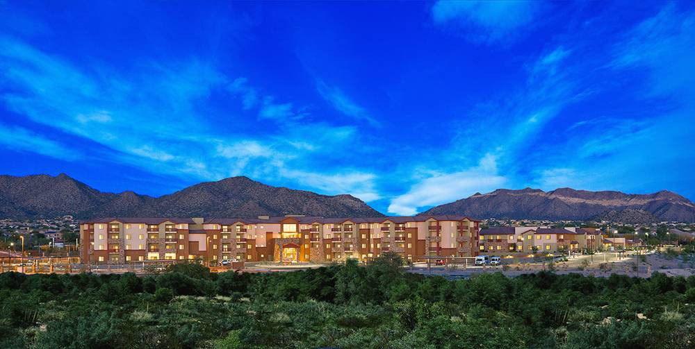 A hotel building set against a backdrop of mountains during the evening.