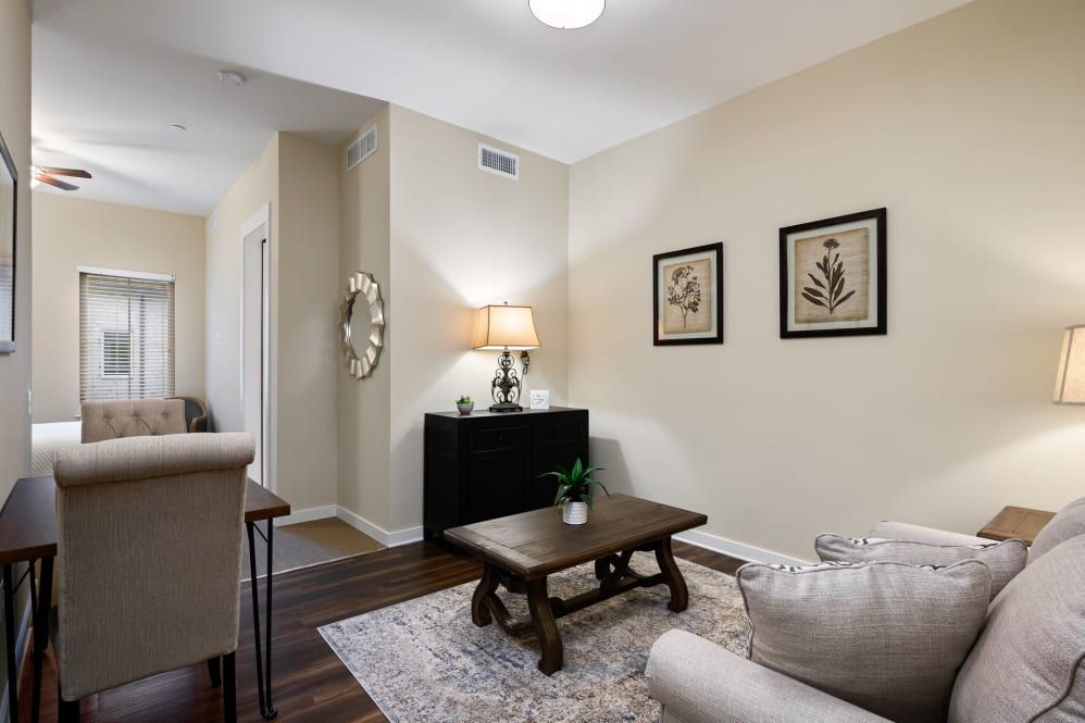 A cozy living room featuring a coffee table, artwork on the walls, and subtle lighting.