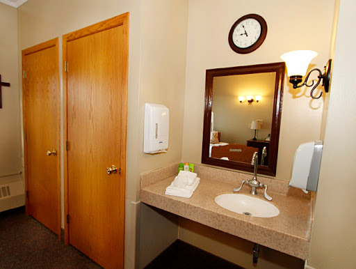 A clean and tidy bathroom featuring a sink, mirror, and wooden doors.