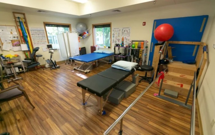 A physical therapy room equipped with various rehabilitation and exercise equipment.