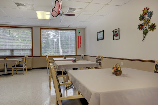 A minimalist dining room with neatly arranged tables and a bright window.