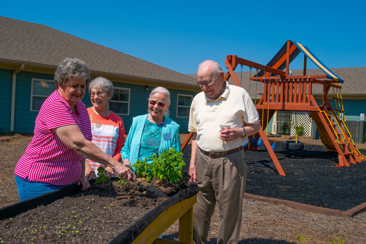 A group of seniors enjoying outdoor gardening in a community setting.