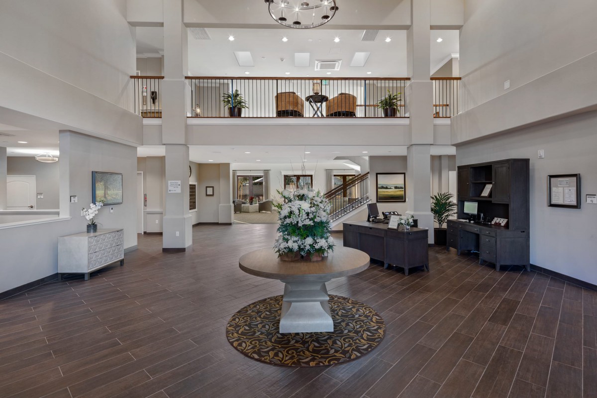 A spacious and elegantly designed lobby with modern furniture and a central floral arrangement.