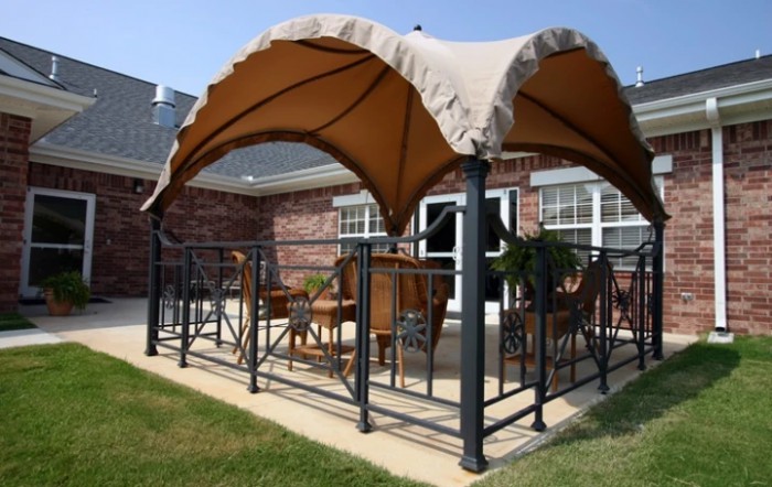 A cozy patio area with a stylish canopy providing shade over outdoor furniture.