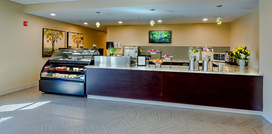 A modern cafe interior with a service counter and food display.