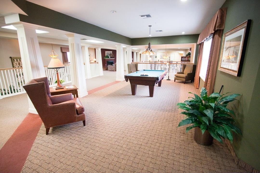 A spacious game room with a pool table and comfortable seating.