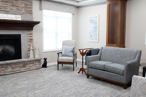 A modern and cozy living room featuring a comfortable gray sofa, an armchair, and a stylish fireplace.