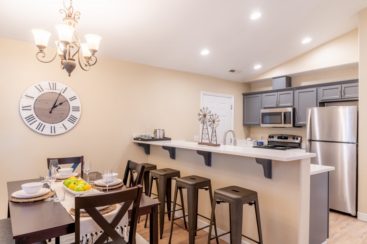 A modern kitchen with a dining area featuring bar stools and stylish decor.
