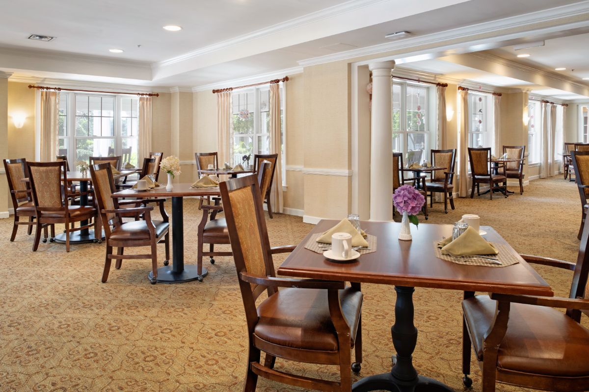 An elegant dining room with neatly arranged tables and chairs, featuring a warm and inviting atmosphere.