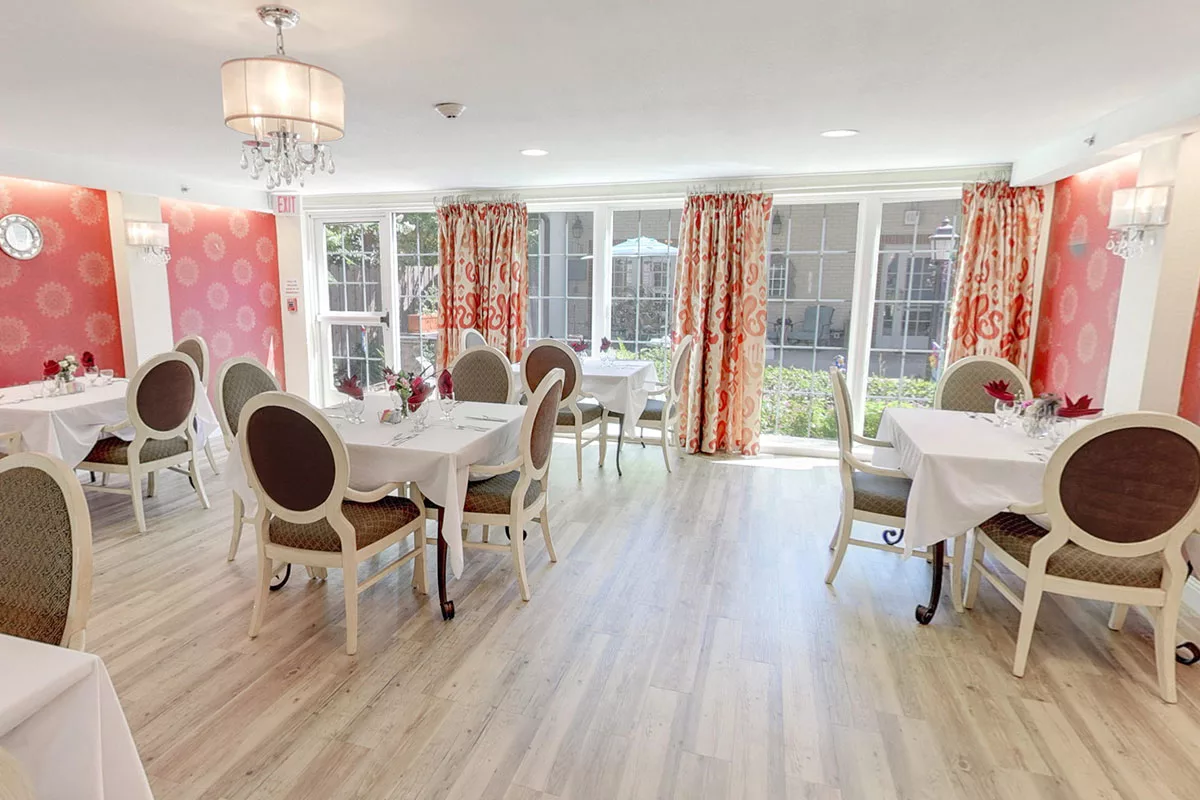 Elegant dining area with large windows and colorful curtains.