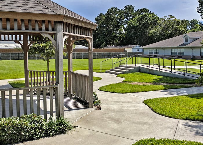 A peaceful backyard with a gazebo, winding pathways, and well-maintained lawns.