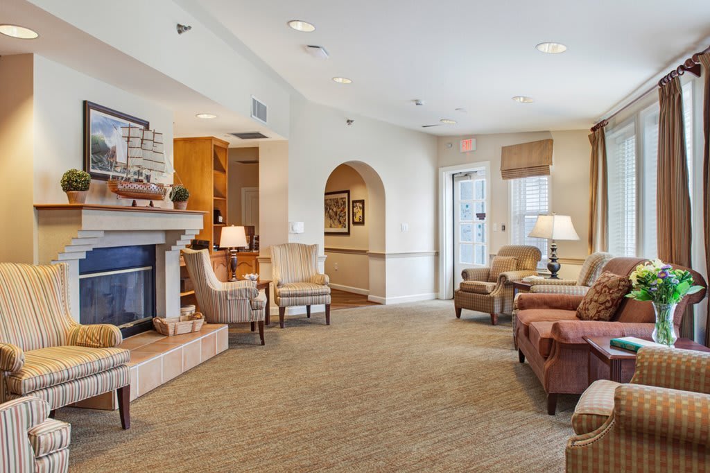 A cozy living room featuring a fireplace, comfortable seating, and warm lighting.