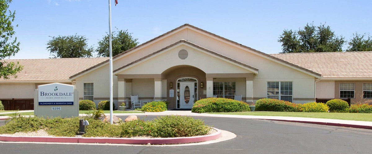 A front view of a building with well-maintained landscaping and an entrance flanked by columns.