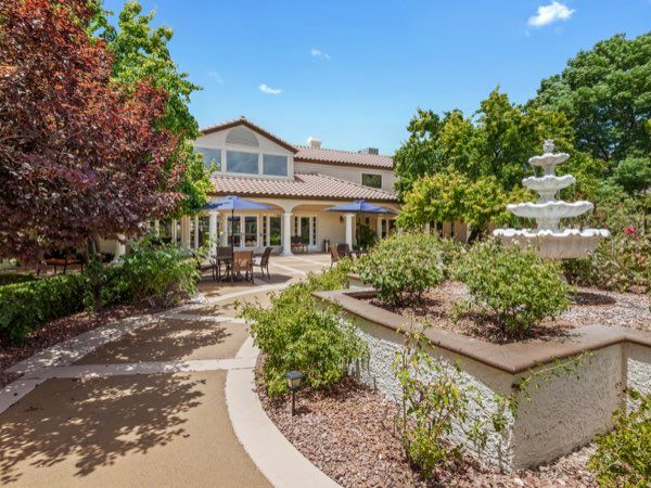 A beautiful house with a well-maintained garden and a decorative fountain.
