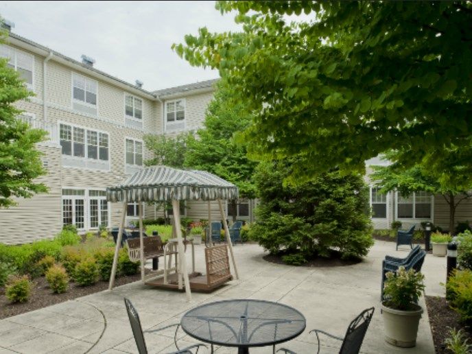 A peaceful courtyard with a gazebo and outdoor seating surrounded by trees.