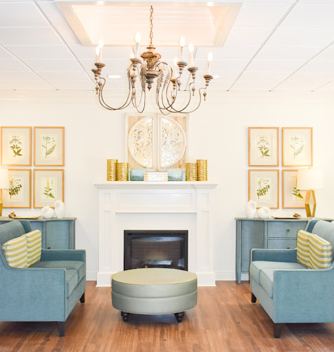 A beautifully designed living room featuring a stylish chandelier, cozy seating, and elegant decor.