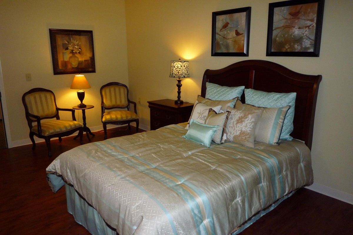 A cozy bedroom with stylish bedding, soft lighting from lamps, and elegant decor.