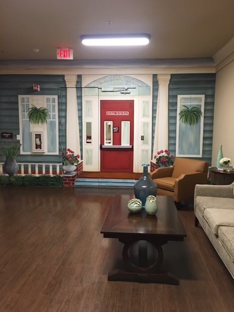 A cozy indoor setting featuring a living room with decorative murals resembling an outdoor facade.