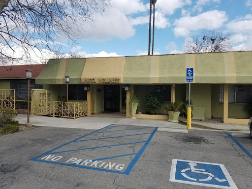 A view of a building with a designated handicap parking area and a no parking sign in front.