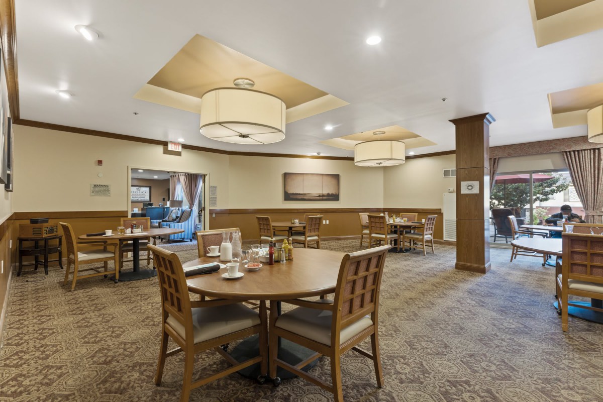 A cozy dining area with warm lighting and neatly arranged tables and chairs.