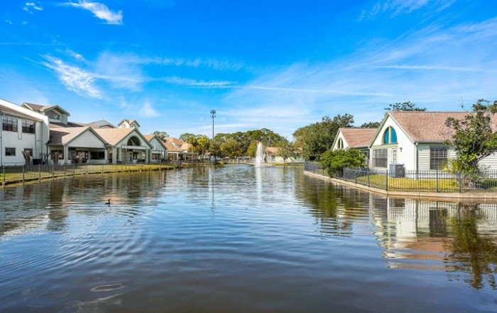 Flooded residential neighborhood under a clear blue sky.
