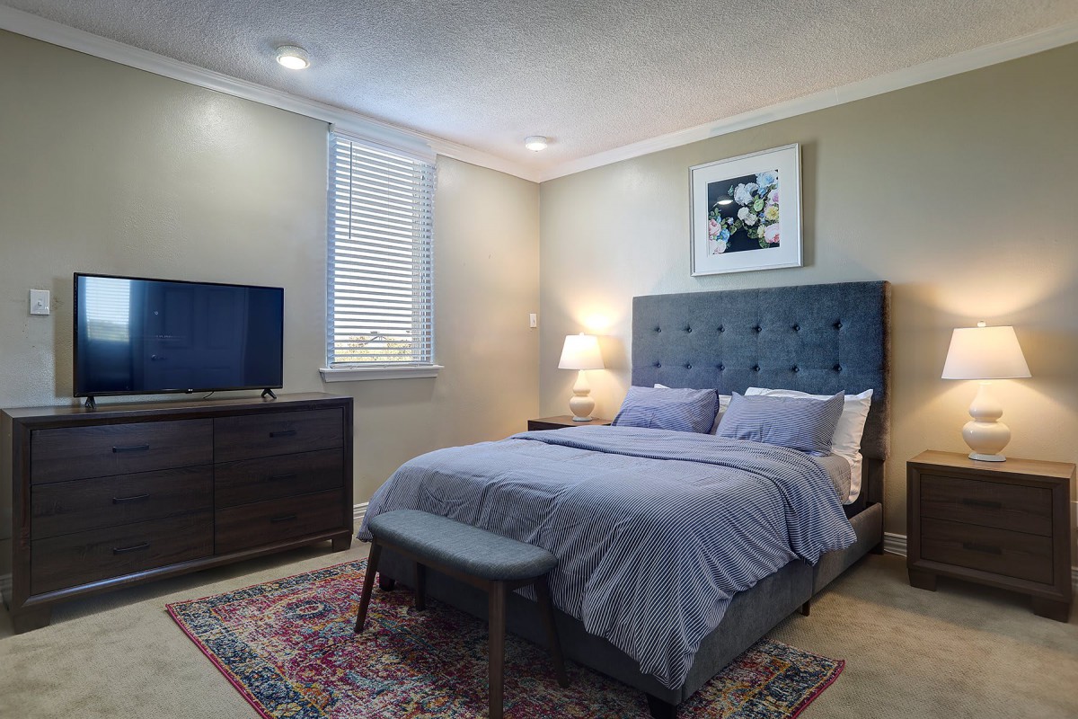 A cozy and well-decorated bedroom with a comfortable bed, modern furniture, and soft lighting.