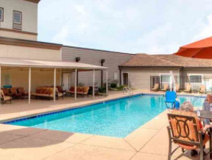 An inviting outdoor swimming pool with surrounding seating and a shaded patio.