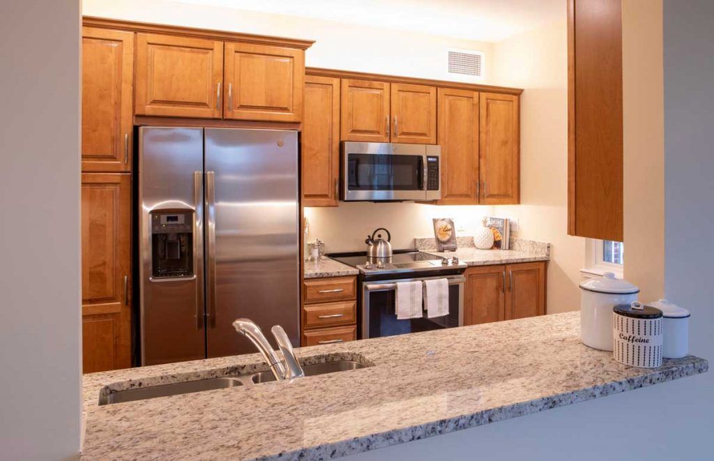 A modern kitchen with wood cabinets and stainless steel appliances.