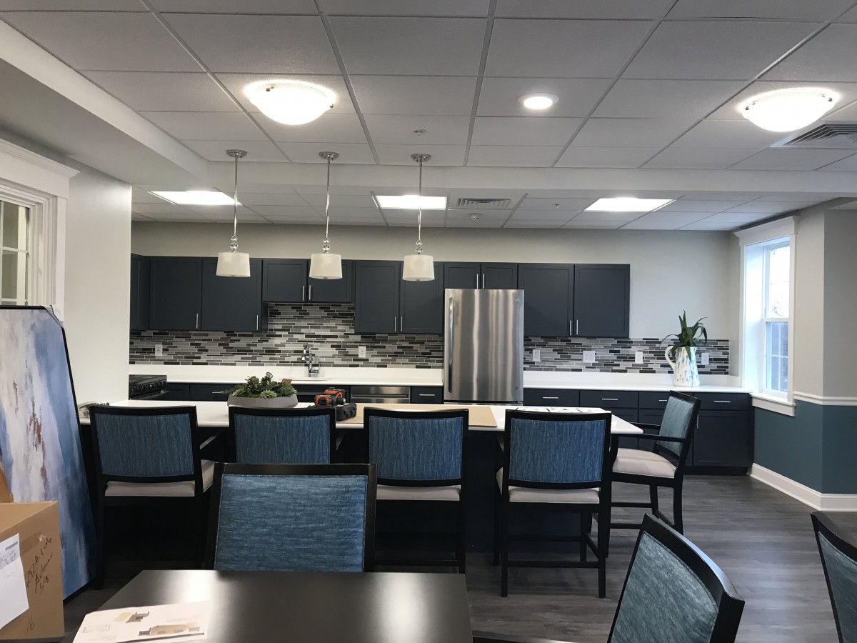 A modern kitchen interior with sleek cabinets, pendant lighting, and a central island.
