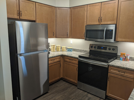 A modern kitchen featuring stainless steel appliances and wooden cabinets.
