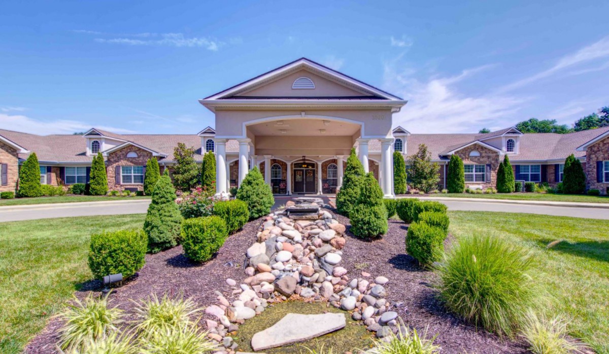 A well-landscaped building entrance on a sunny day.