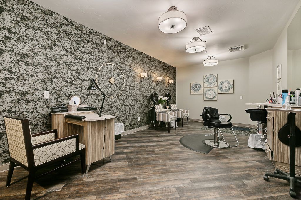 A stylish and modern salon interior with elegant wallpaper and contemporary furnishings.