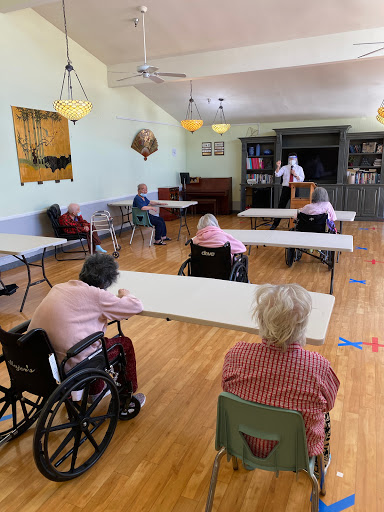 Elderly individuals participating in a group presentation at a community center.