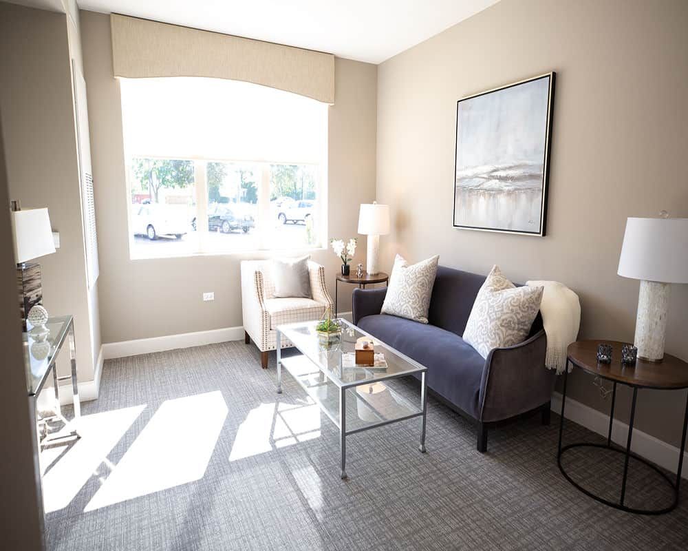 A bright and cozy living room with a sofa, chairs, and a coffee table.