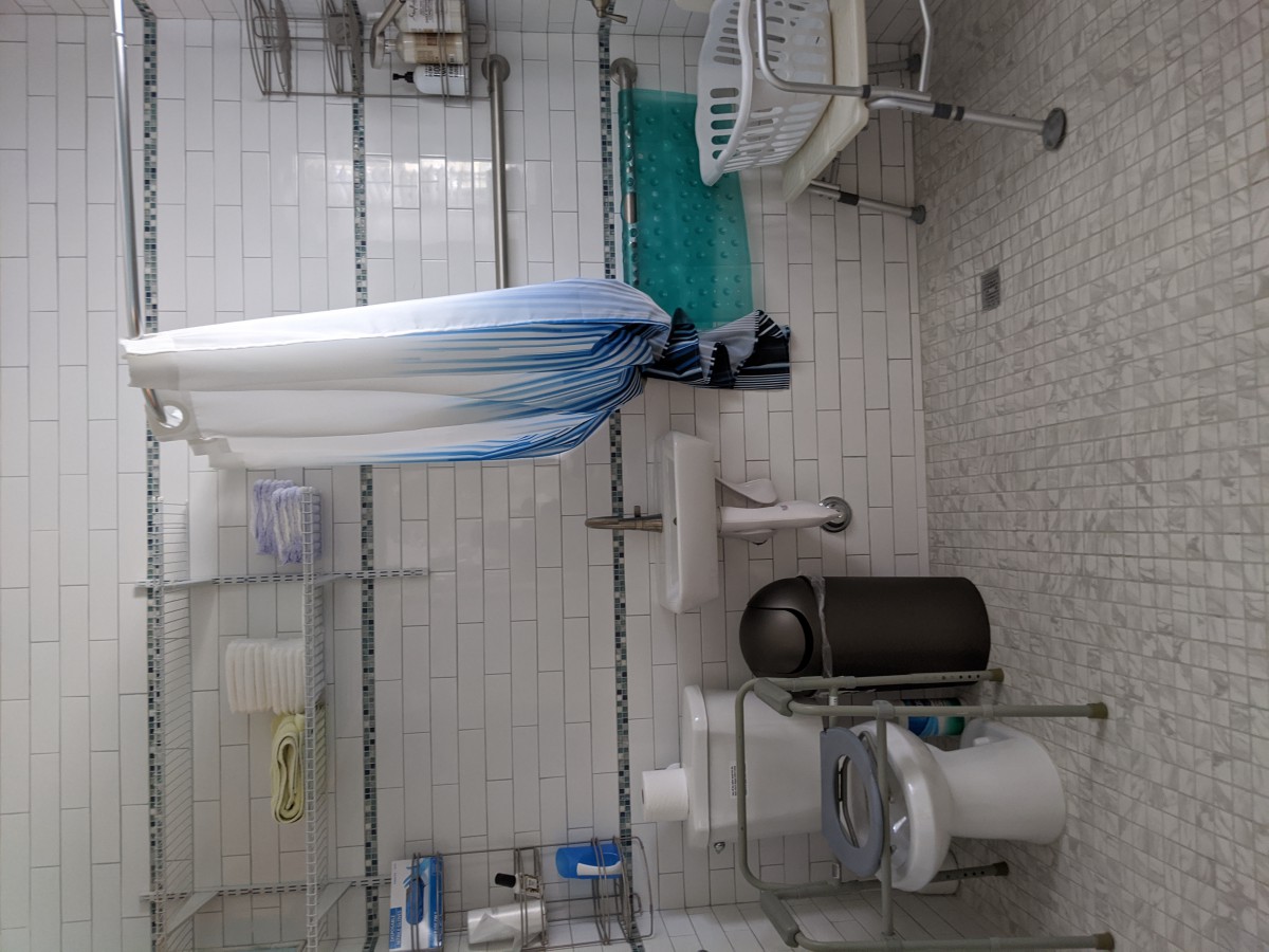 A clean and organized bathroom with a shower area, toilet, and sink.