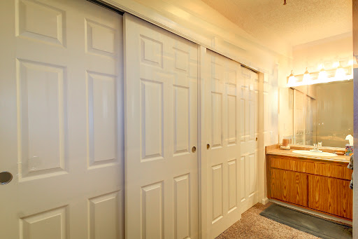 An interior view of a bathroom featuring sliding doors and a wooden vanity.