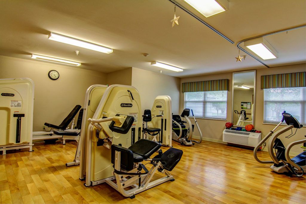 A well-equipped gym featuring exercise machines and bright lighting.