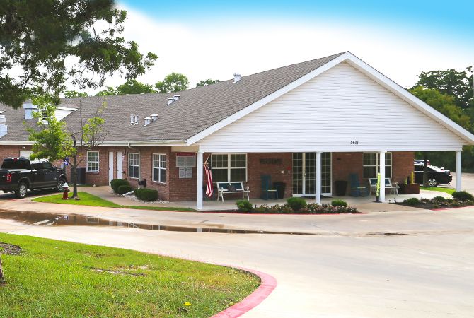 A suburban residential building with a covered porch and driveway.