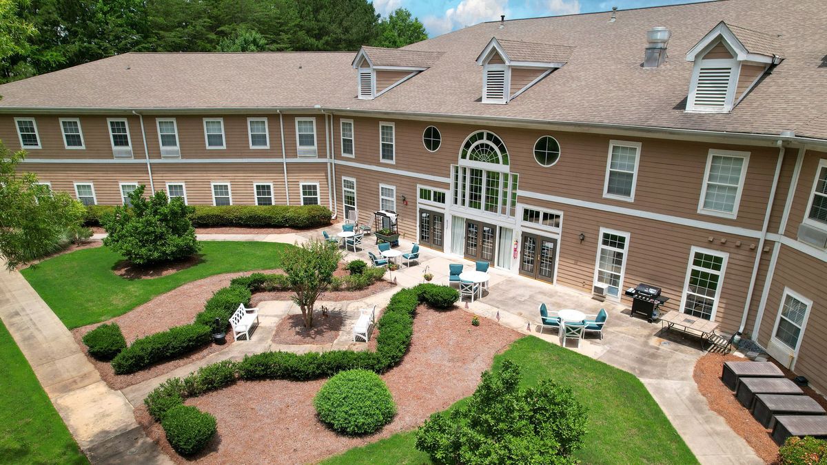 Aerial view of a building with a landscaped garden and outdoor seating area.