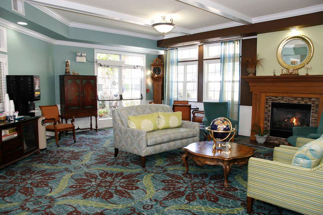 A cozy living room with elegant furniture and colorful carpeting.