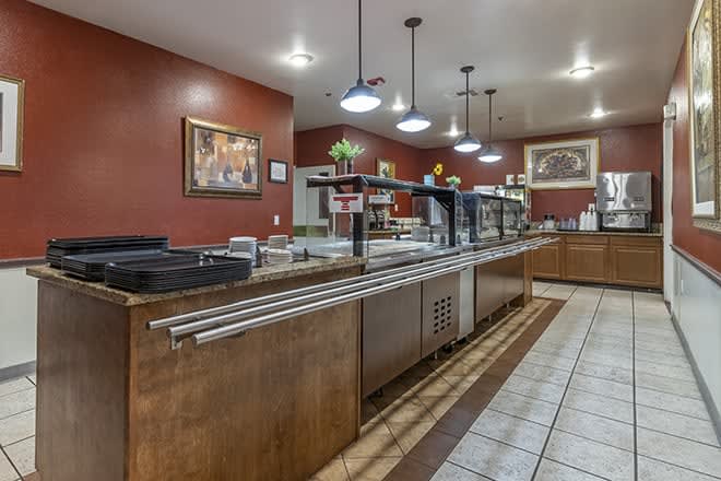 An empty cafeteria with a serving counter and warm lighting.