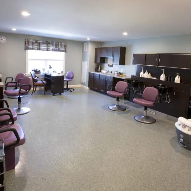 Modern hair salon interior with multiple chairs and workstations.