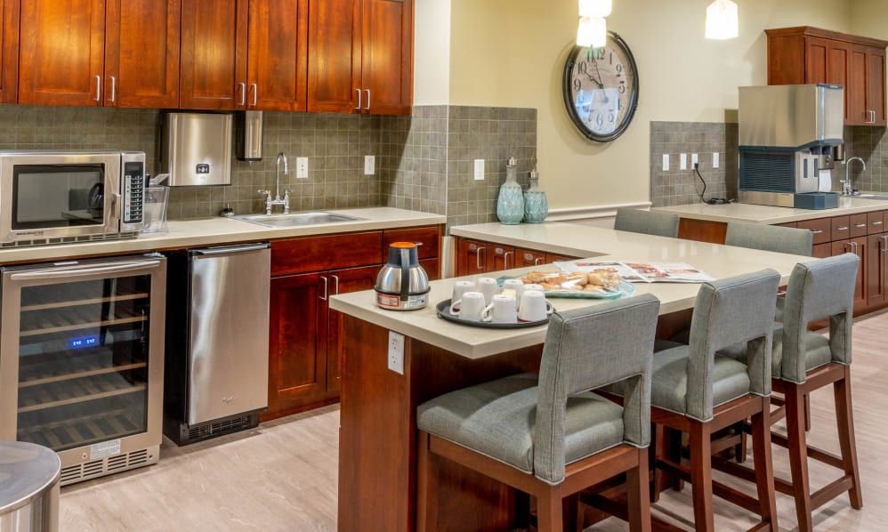 A modern kitchen with wooden cabinets, an island counter, and bar stools.