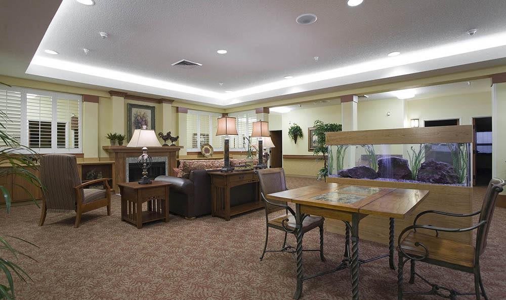 A cozy living room with comfortable seating, tables, and a fireplace.