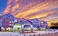 A residential building complex under a vibrant sunset sky.
