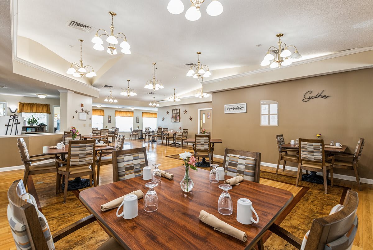 A well-lit dining area with neatly arranged tables and chairs in a restaurant setting.