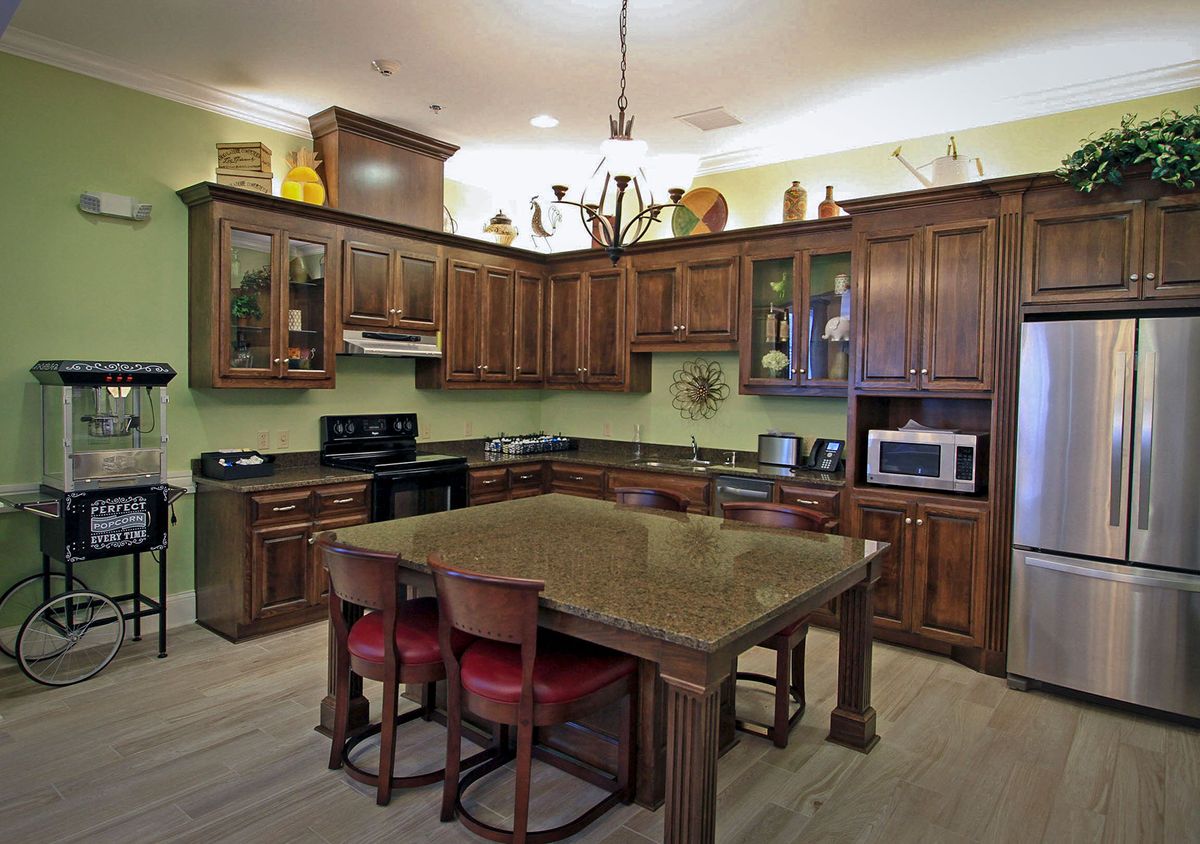 A spacious kitchen with wooden cabinets, a central island, and modern appliances.