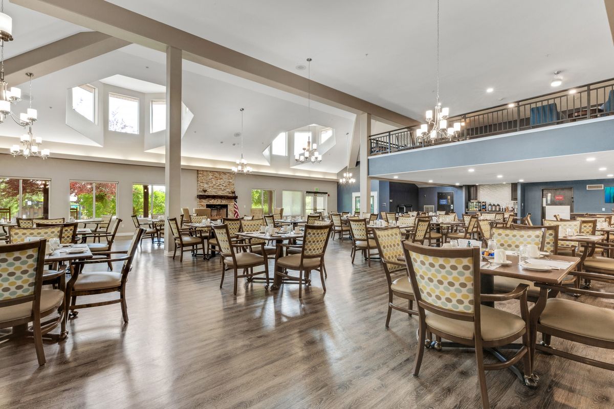 A spacious dining room with elegant furniture and chandeliers.