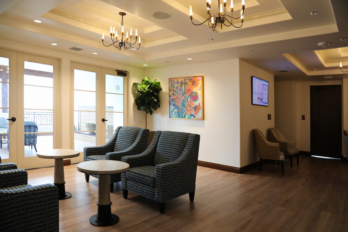 A modern lobby with comfortable seating, decorative chandeliers, and colorful artwork.