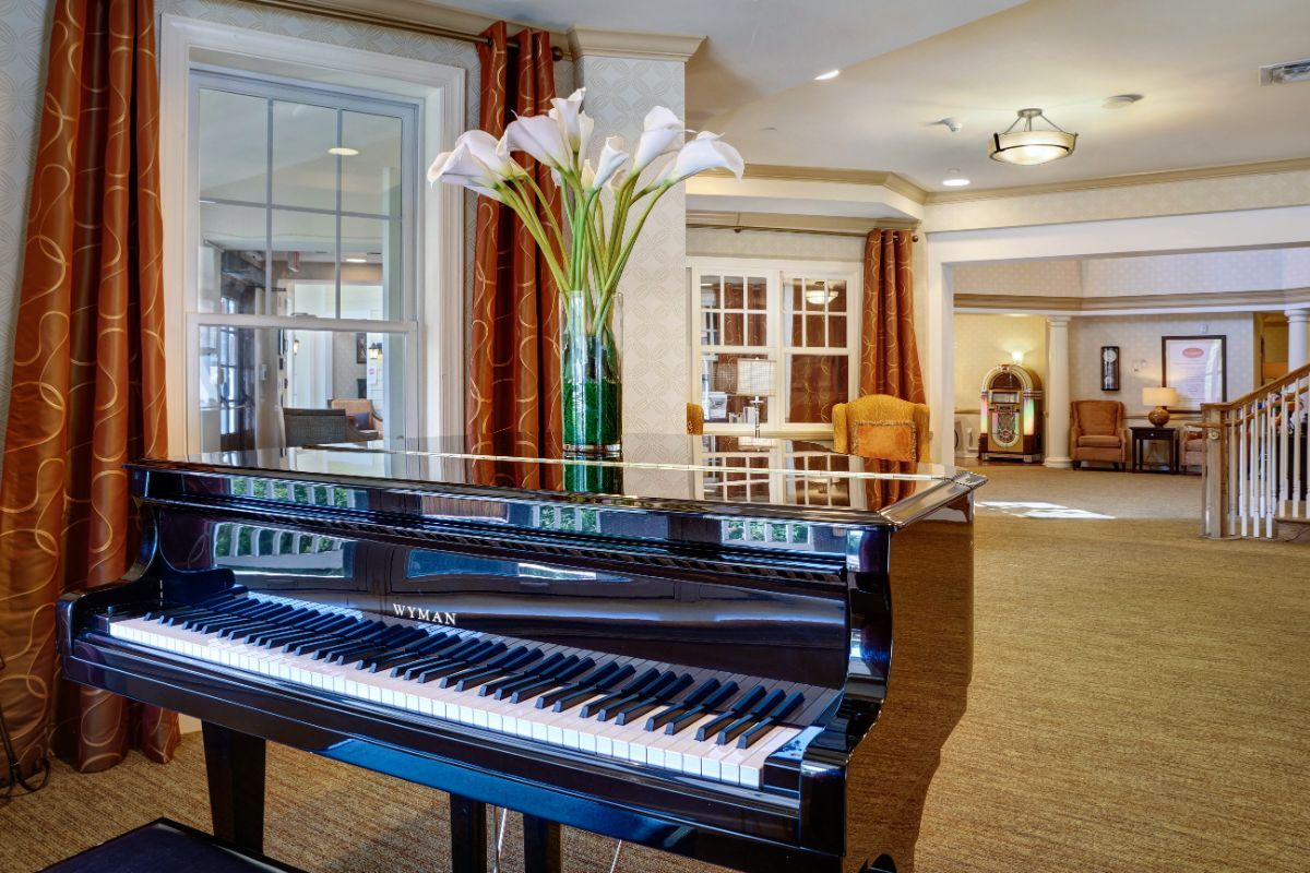 A grand piano with a vase of flowers in an elegant living room.